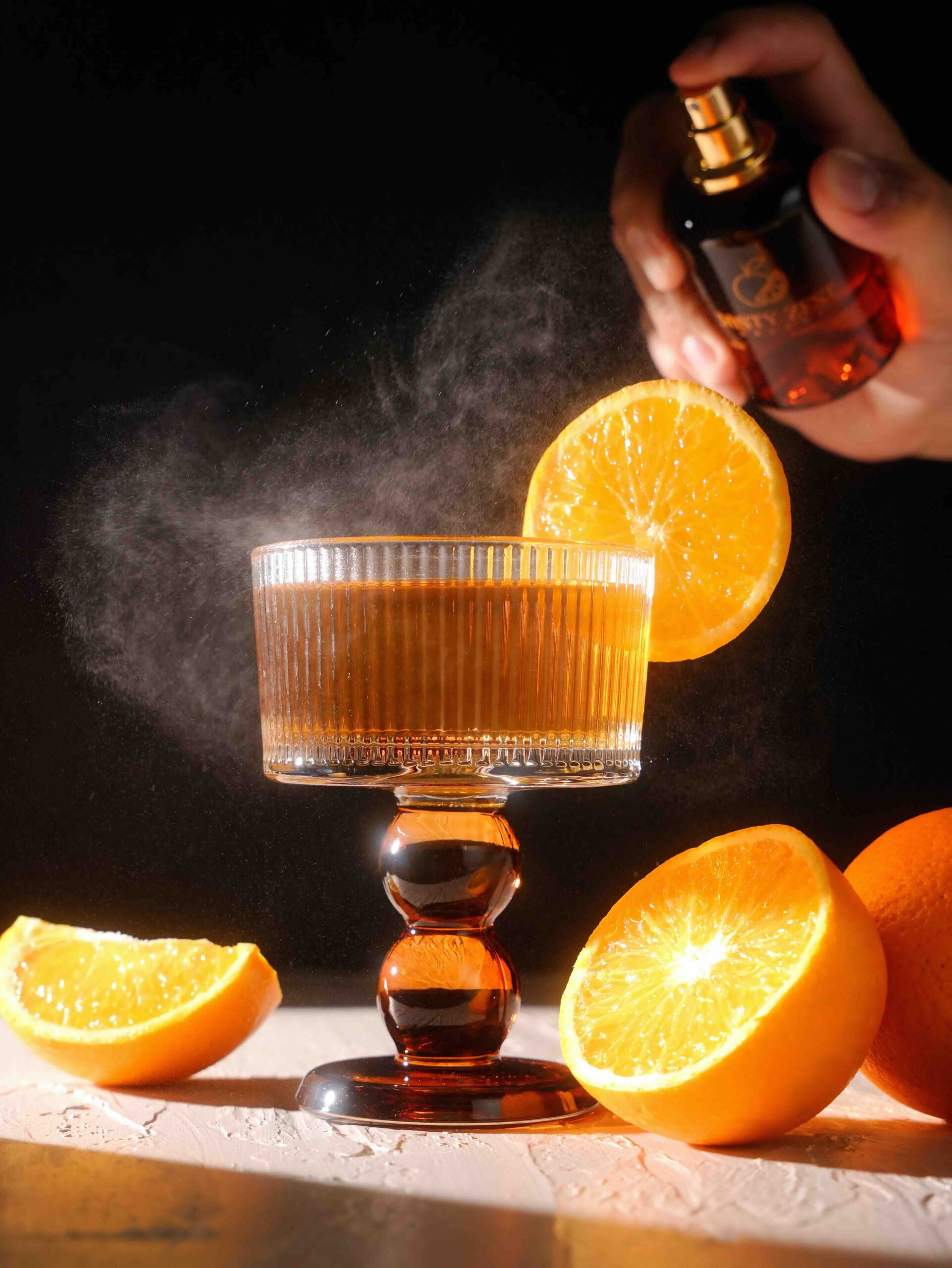 Misty Zest Styled Product Photography. Showing Cocktail with spray and some orange in artistic way